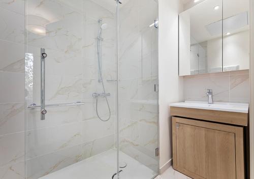 a bathroom with a glass shower and a sink at Zenao Appart'hôtels Saint-Mandé in Saint-Mandé