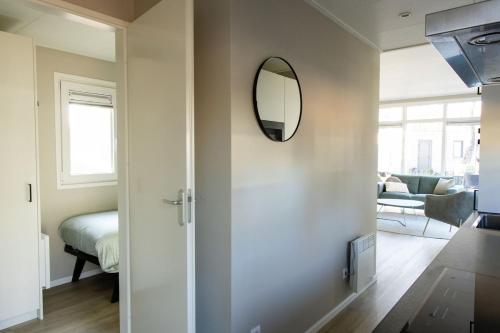 a living room with a mirror on the wall at Chalet Bosrijk in Haarle
