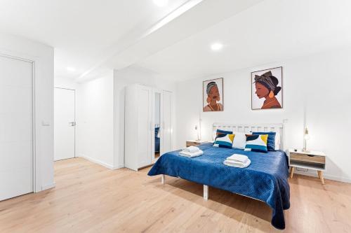 a white bedroom with a blue bed with blue sheets at A unique experience in Porto in Porto