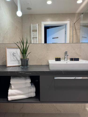 a bathroom with a sink and a mirror and towels at Baltic Infinity Suite 413 - SPA & Pool Access in Międzyzdroje