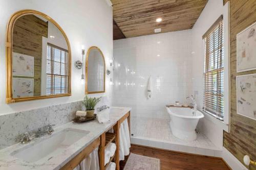 a bathroom with a tub and a sink at Rustic Luxury - As Seen on "Restoring Galveston" TV Show in Galveston