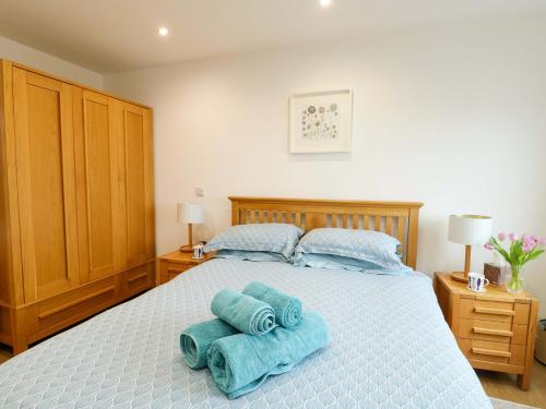 a bedroom with a bed with blue towels on it at Maelog, 14 Tides Reach in Rhosneigr