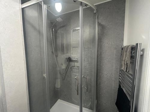 a shower with a glass door in a bathroom at Solway Firth View in Annan