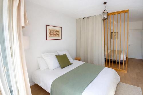 a bedroom with a bed with white and green sheets at Le Caballo - Appartement de charme à Digoin in Digoin