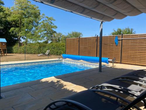 a swimming pool with blue water in a yard at Maison du Figuier 1799 in Nanclars
