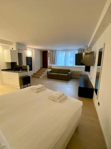 a bedroom with a large white bed and a living room at ANTONELLA's ROOM in Bresso