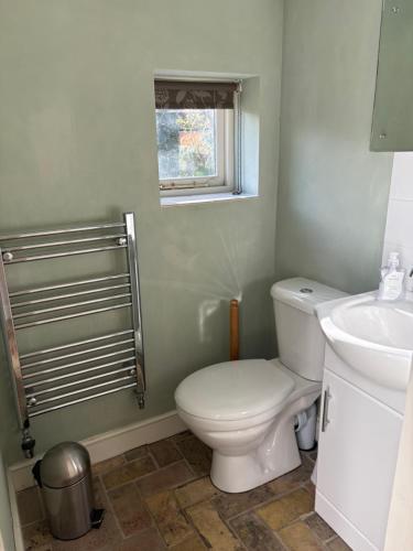 a bathroom with a toilet and a sink at The Old Post Office, Hilton in Huntingdon