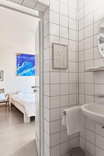 a white bathroom with a sink and a bed at Schloss Blumenfeld in Tengen