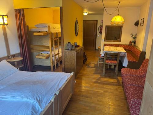 a bedroom with a bed and a dining room with a table at Campiglio Monolocale Cima Tosa in Madonna di Campiglio