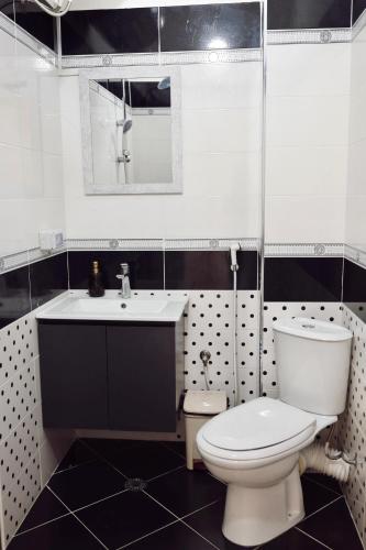 a white bathroom with a toilet and a sink at HeartStay Shkodra in Shkodër