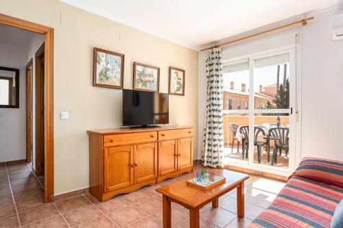a living room with a couch and a tv at Jardín del Golf2 9 1A in Novo Sancti Petri
