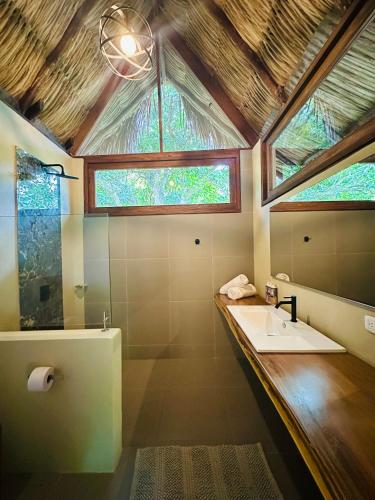 a bathroom with a sink and a large window at Senda Koguiwa Tayrona Nature Hotel in El Zaino