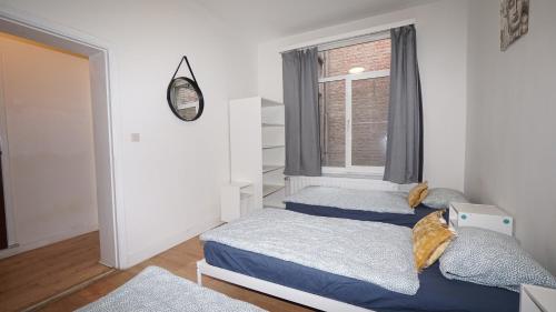 a bedroom with two beds and a window at Plantin Apartment in Antwerp