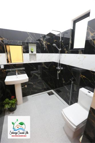 a bathroom with a toilet and a sink at Sinharaja Cascade Villa in Deniyaya