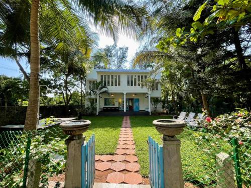 a white house with a fence and a yard at La Maison Bougainvillea in Mahabalipuram