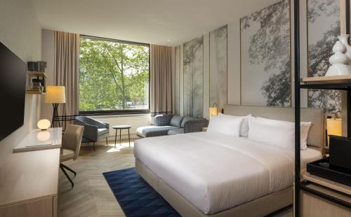 a bedroom with a bed and a living room at DoubleTree by Hilton Berlin Ku'damm in Berlin