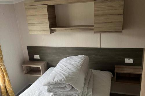 a bedroom with a bed with a wooden headboard at Caravan- Sleeps 6 2 Bedrooms - Thurston Manor in Dunbar