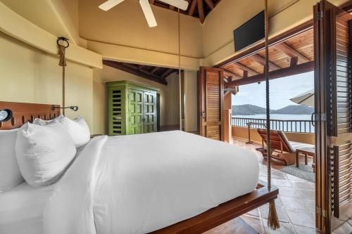 a bedroom with a bed and a balcony at Hilton Grand Vacations Club Zihuatanejo in Zihuatanejo