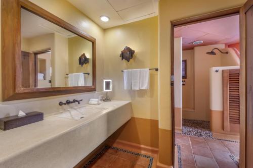 a bathroom with a large sink and a mirror at Hilton Grand Vacations Club Zihuatanejo in Zihuatanejo