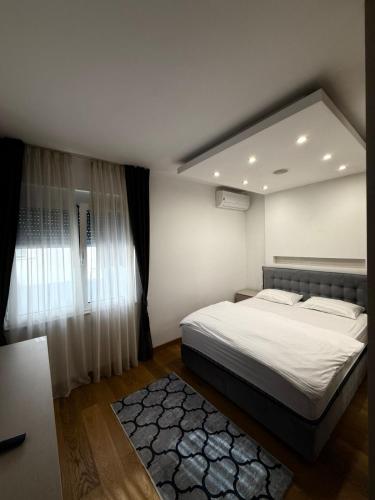 a bedroom with a large bed and a window at Eden apartments in Tivat