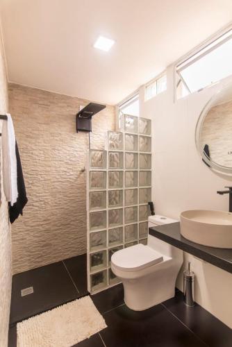 a bathroom with a toilet and a sink at Golden Pipa House in Pipa