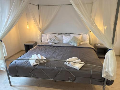 a bedroom with a canopy bed with towels on it at Villa BRUNI Wine Guest House in Montefalco