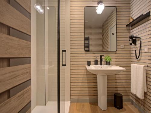 a bathroom with a sink and a mirror at Hotel Faisanera Golf in Palazuelos de Eresma