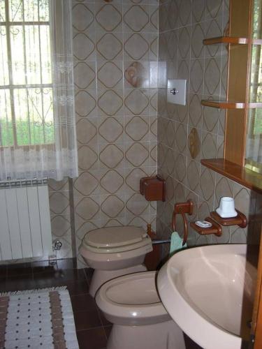 a bathroom with a toilet and a sink at Villa Rocca in Marciaga