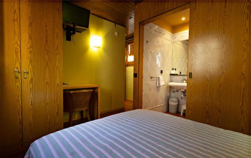 a bedroom with a bed and a bathroom with a sink at Hostal Victor in Oliana