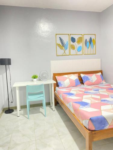 a bedroom with a bed and a desk and a table at ZK Homestay in Puerto Princesa City