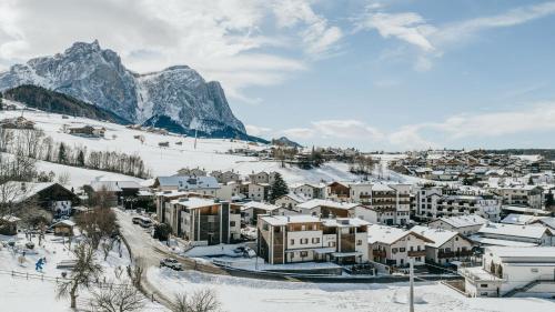 a town covered in snow with a mountain in the background at Apartments Scherlin in Castelrotto