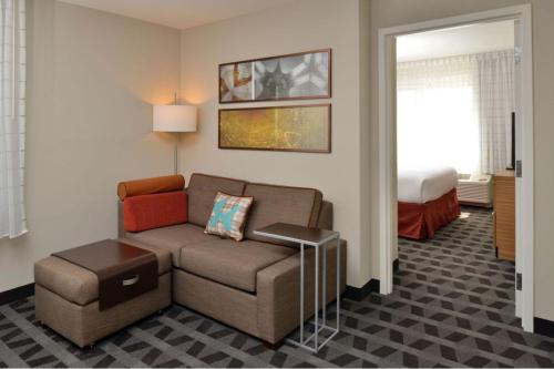 a living room with a couch and a bed at TownePlace Suites by Marriott Raleigh Durham Airport Morrisville in Morrisville
