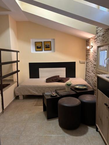 a bedroom with a bed and a table and stools at Guest house Kozle in Skopje