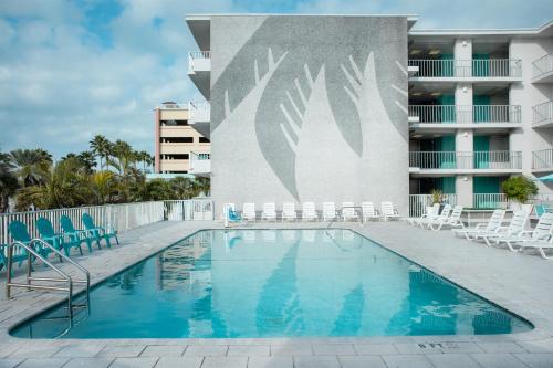 a swimming pool with chairs and a building at The Beachview Inn Clearwater Beach in Clearwater Beach