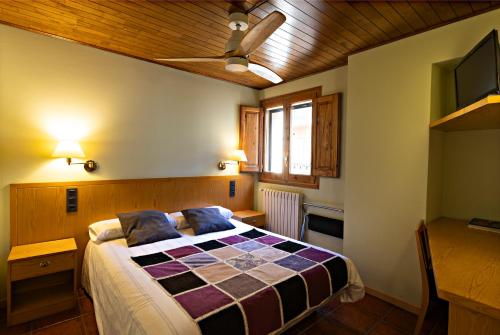 a bedroom with a bed and a table and a window at Hostal Victor in Oliana