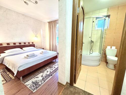 a bedroom with a bed and a shower and a toilet at Садиба в горах in Solochyn