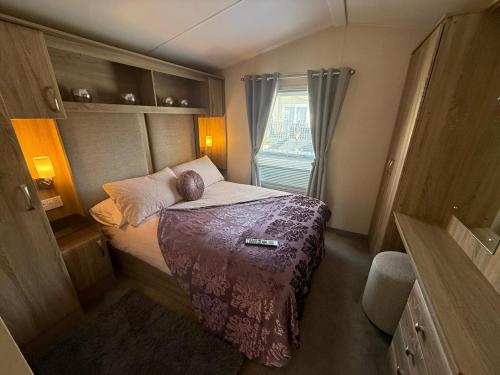 a small bedroom with a bed and a window at Sunset Serenity - 4 Sunset View in Crowle