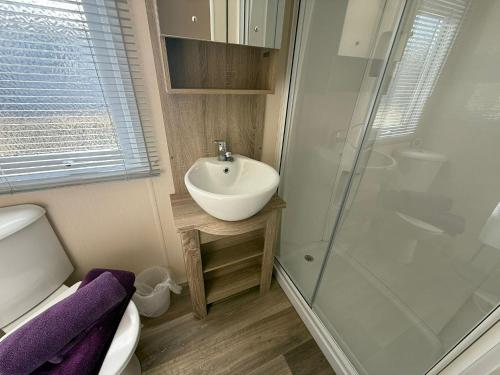 a small bathroom with a sink and a shower at Sunset Serenity - 4 Sunset View in Crowle