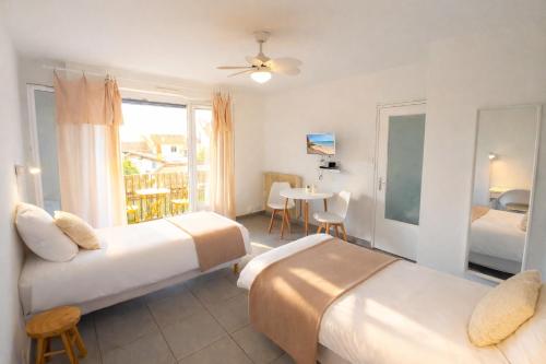 a hotel room with two beds and a table at Le Twins - Appartement de charme à Digoin in Digoin