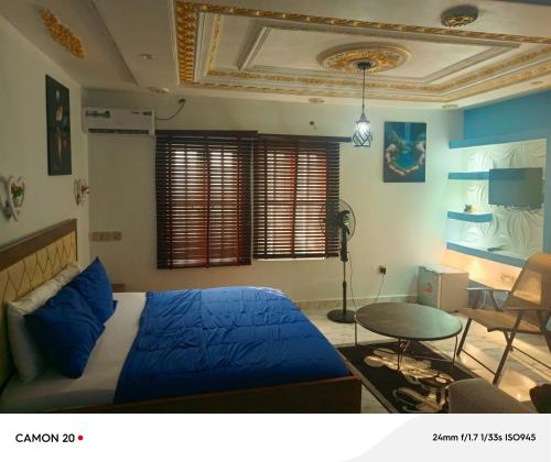 a bedroom with a blue bed and a table at RichRoyal Hotels Ltd in Oruama