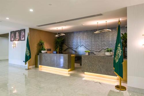 a lobby with a reception desk and two flags at DoubleTree by Hilton Jeddah - Alandalus Mall in Jeddah