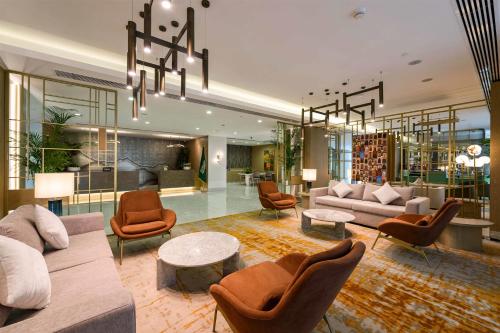 a living room with furniture and a chandelier at DoubleTree by Hilton Jeddah - Alandalus Mall in Jeddah