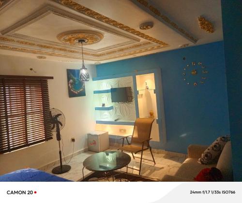 a living room with blue walls and a table at RichRoyal Hotels Ltd in Oruama