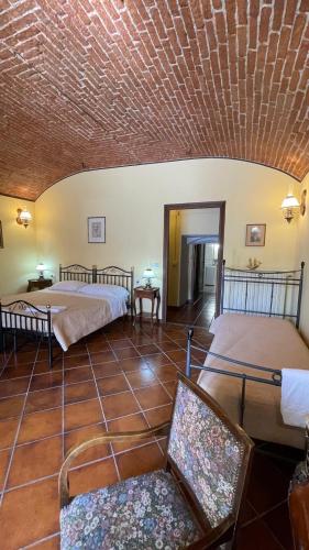 a room with a bed and a chair and a ceiling at Casa del Grande Vecchio 2 in Airasca