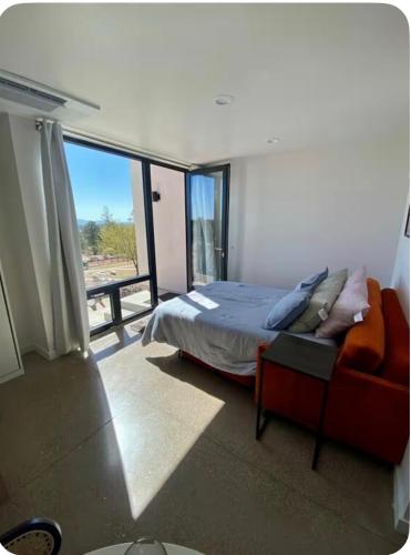 a bedroom with a bed and a couch and a window at Casita in Los Alamos