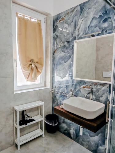 a bathroom with a sink and a blue marble wall at Termoli in una stanza in Termoli
