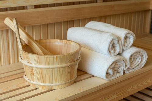 een stapel handdoeken en een mand in een sauna bij Belsit Apartments in Venas