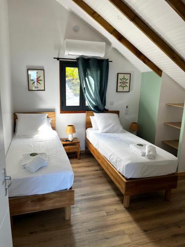 a bedroom with two beds and a window at Caribbean Shelter in Bouillante
