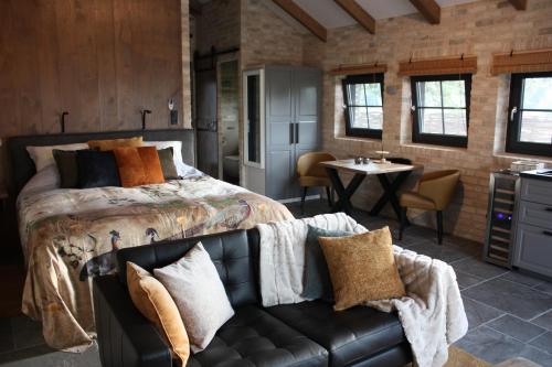a bedroom with a bed and a couch and a table at Ferienhaus Sweet-Escape in Löningen
