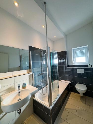 a bathroom with a sink and a shower and a toilet at Victoria Living in Jockgrim